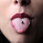 Tongue piercings may be marginally safer with plastic stud material.