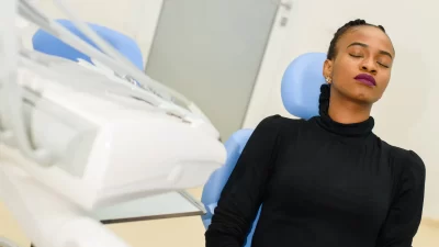 African-American with eyes closed in a dental chair.