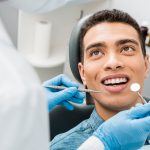 Dentists agree that maintaining strong teeth requires more than daily brushing, flossing, and semi-annual dental check-ups. To further reduce the risk of cavities, they often recommend preventive treatments like dental sealants. Sealants are thin protective coatings applied to the chewing surfaces of molars and premolars to prevent cavities and decay. How Are Dental Sealants Applied? The sealant process involves several steps to ensure a secure bond with the tooth: First, the dentist or hygienist thoroughly cleans the tooth to remove plaque, food particles, and bacteria. Next, the surface is dried and a cotton roll or dry-angle is placed around the tooth to keep it dry. Then a mild acidic solution is applied to roughen the surface of the tooth, helping the sealant adhere properly. After this, the tooth is rinsed and dried again. After preparing the tooth with the steps above, the liquid sealant is brushed onto the tooth’s surface, filling in the grooves and pits. A special blue light hardens the sealant quickly. To complete the process, the dentist makes minor adjustments to ensure the sealant is providing proper coverage of the tooth, is smooth, and has not affected your natural bite.   Can Dental Sealants Trap Cavities Underneath? Some wonder if it’s possible for a sealant to trap a cavity on the surface of the tooth under the sealant. The short answer is yes, however if all of the steps for preparing the tooth and applying the sealant is followed, then this is highly unlikely. Dentists use their expertise to assess a tooth before sealing it. If any signs of decay appear, most recommend treating it first with fluoride or a small filling before applying the sealant. Regular checkups help ensure that sealants remain intact and effective. Is Your Sealant Still Effective? As with most things in life, sealants wear down with age due to chewing and exposure to various foods. As it wears, it is important to notice the signs that indicate that a sealant needs professional attention. Here are some things to watch for: Rough or uneven surfaces – A well-applied sealant feels smooth, so rough spots indicate deterioration. Small cracks or chips – Breaks in the sealant allow bacteria to enter, so if you notice cracks or chips, get professional help. Food getting stuck – If food particles frequently lodge in the grooves or crevices of your tooth, the sealant is no longer doing its job and should be replaced. Tooth sensitivity – A previously sealed tooth that becomes sensitive to cold or sweets indicates possible decay. Dentists check sealants during regular visits, reapplying them when necessary to maintain protection. If you have concerns about your sealants, discuss them with your dentist. Enjoy the Benefits of Sealants Dental sealants serve as an effective way to provide years of protection from decay. However, improper application or wear over time requires reapplication of the sealant material. Contact the Placerville Dental Group to ensure your sealants remain intact, helping you maintain strong and healthy teeth!